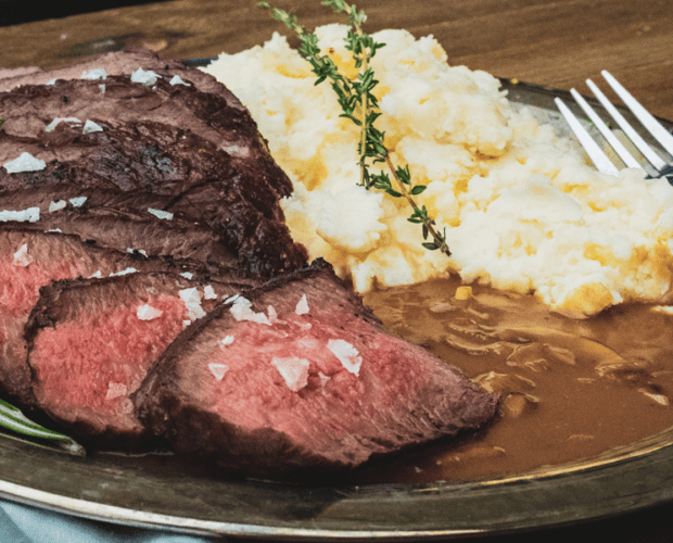 Image of a barbecued tri-tip roast served with shallot and mushroom sauce