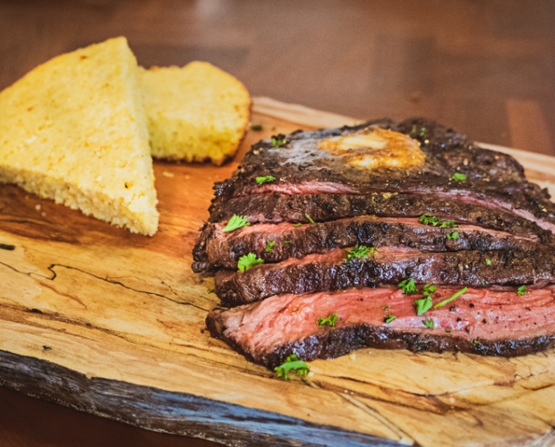 Photograph of sliced grilled Canadian Wagyu beef bavette on a wooden cutting board